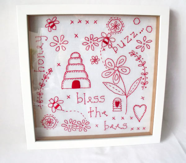 framed red work embroidered bees wall hanging