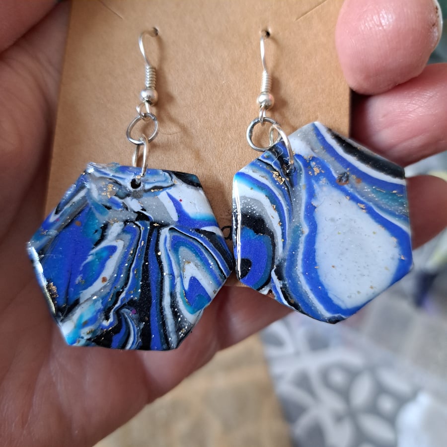 A glittery pair of  blue, white, silver, black and gold polymer clay earrings 