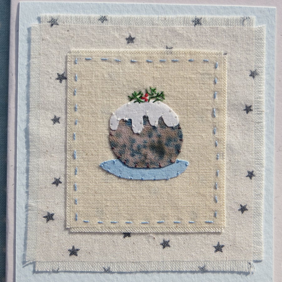 Hand-stitched little pudding with embroidered details and starry background