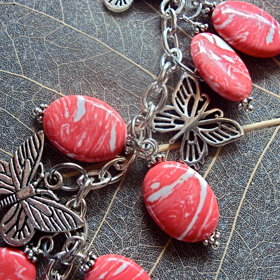 Stripey salmon pink bead and butterfly bag charm
