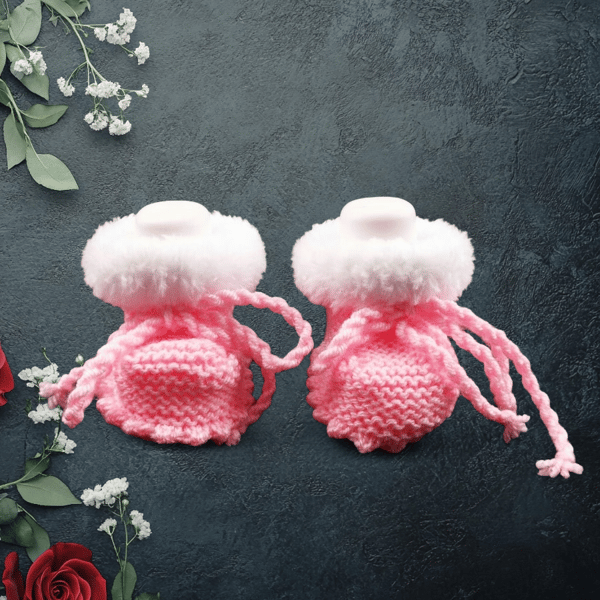 Hand knitted baby pink booties with white faux fur trim 