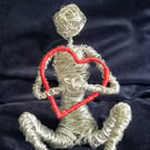 Figure sculptured out of wire Holding onto love