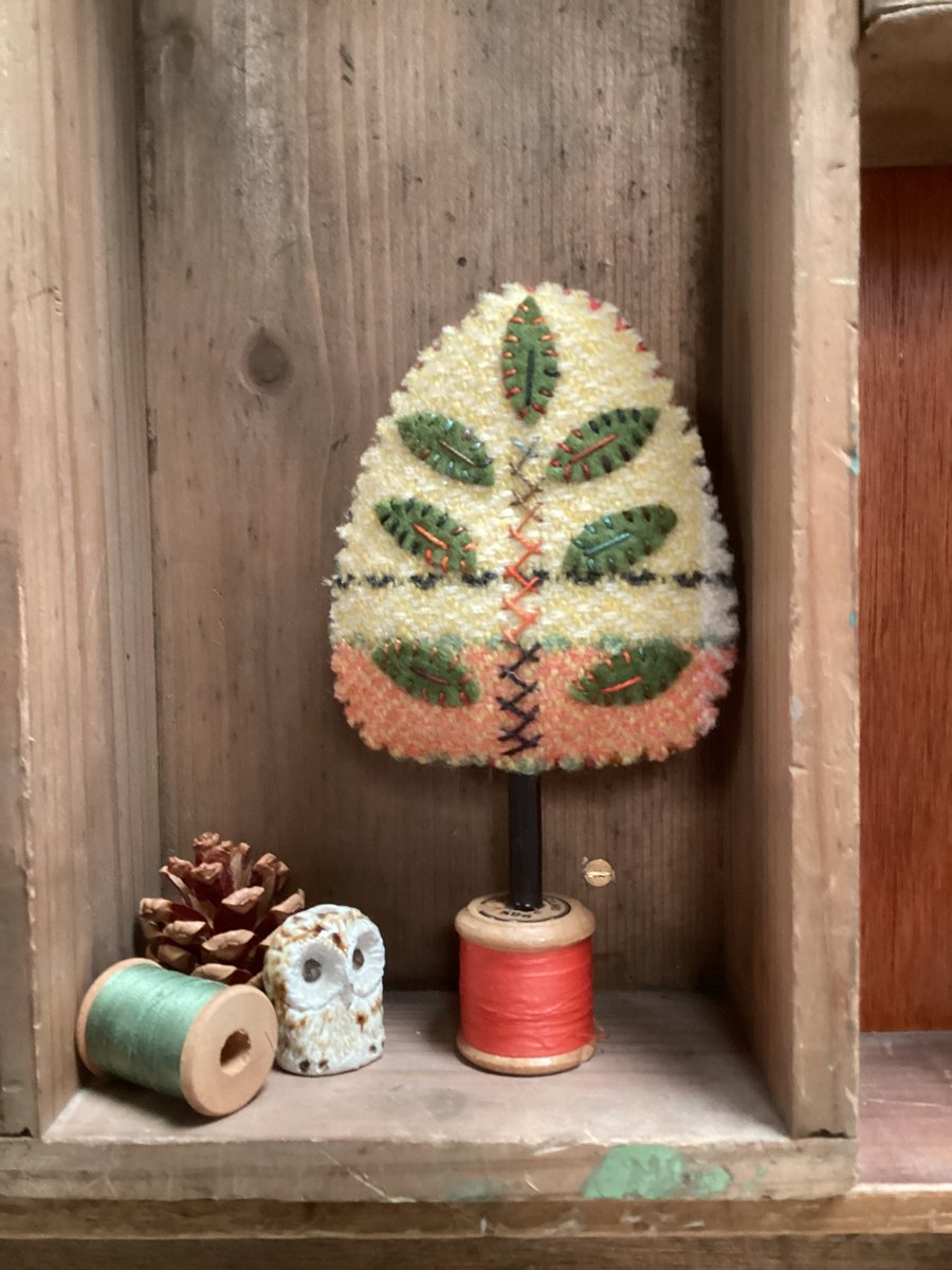 Hand woven yellow tree with green leaves 