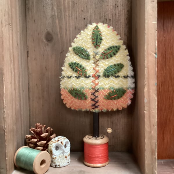 Hand woven yellow tree with green leaves 