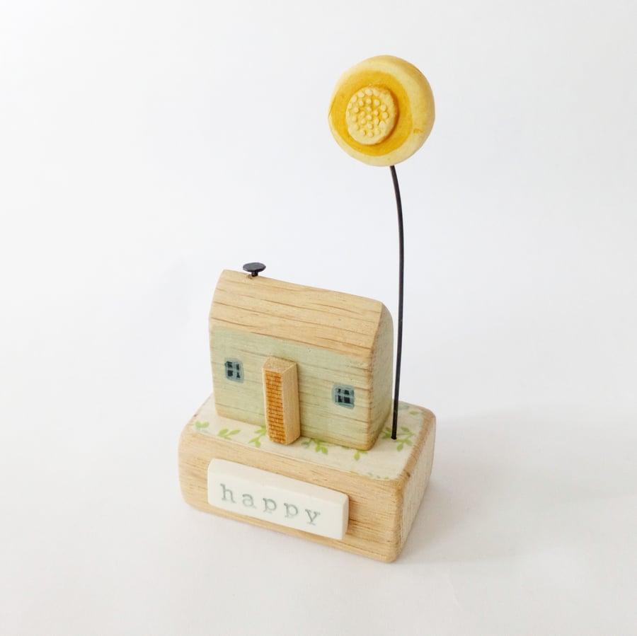 Little wooden happy house with sunflower