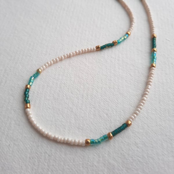 Glass beaded necklace, 'dash' design, cream, gold with green and aqua, 17 to 19"