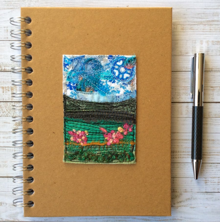 Embroidered landscape with flowers lined hardback notebook. 