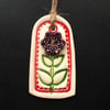 Small red ceramic tag decoration with flower button