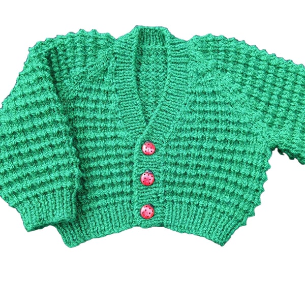 Hand knitted baby cardigan in emerald green with textured pattern  