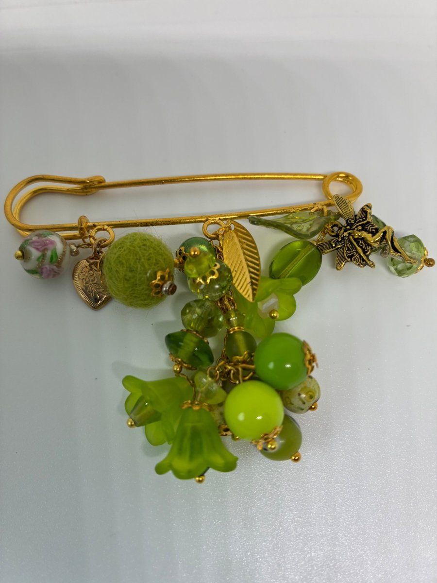 A very bright green kilt pin brooch