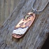 Copper and silver 'snowy hillside' mixed metals scene pendant 