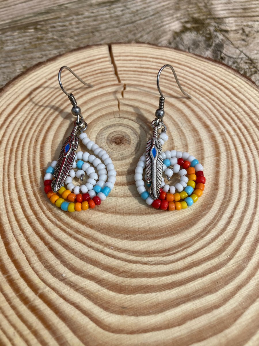 Boho style beaded earrings with a feather charm 