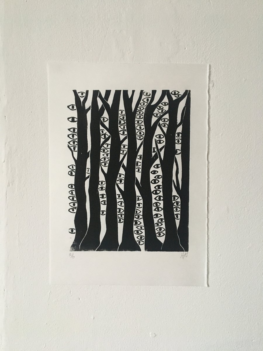 The Woods are Watching linocut print of a forest with eyes.