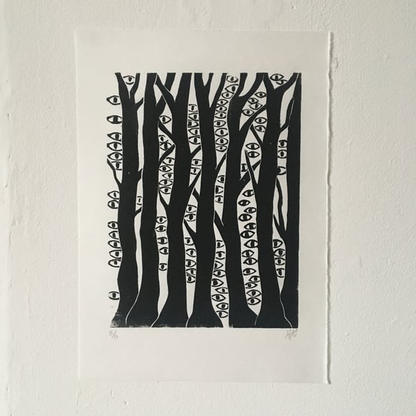 The Woods are Watching linocut print of a forest with eyes.