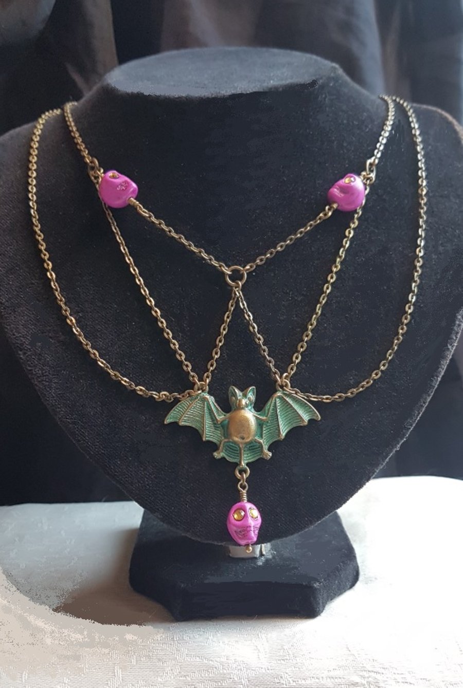 Spooky Antique-look Bat Necklace with Pink Skulls.