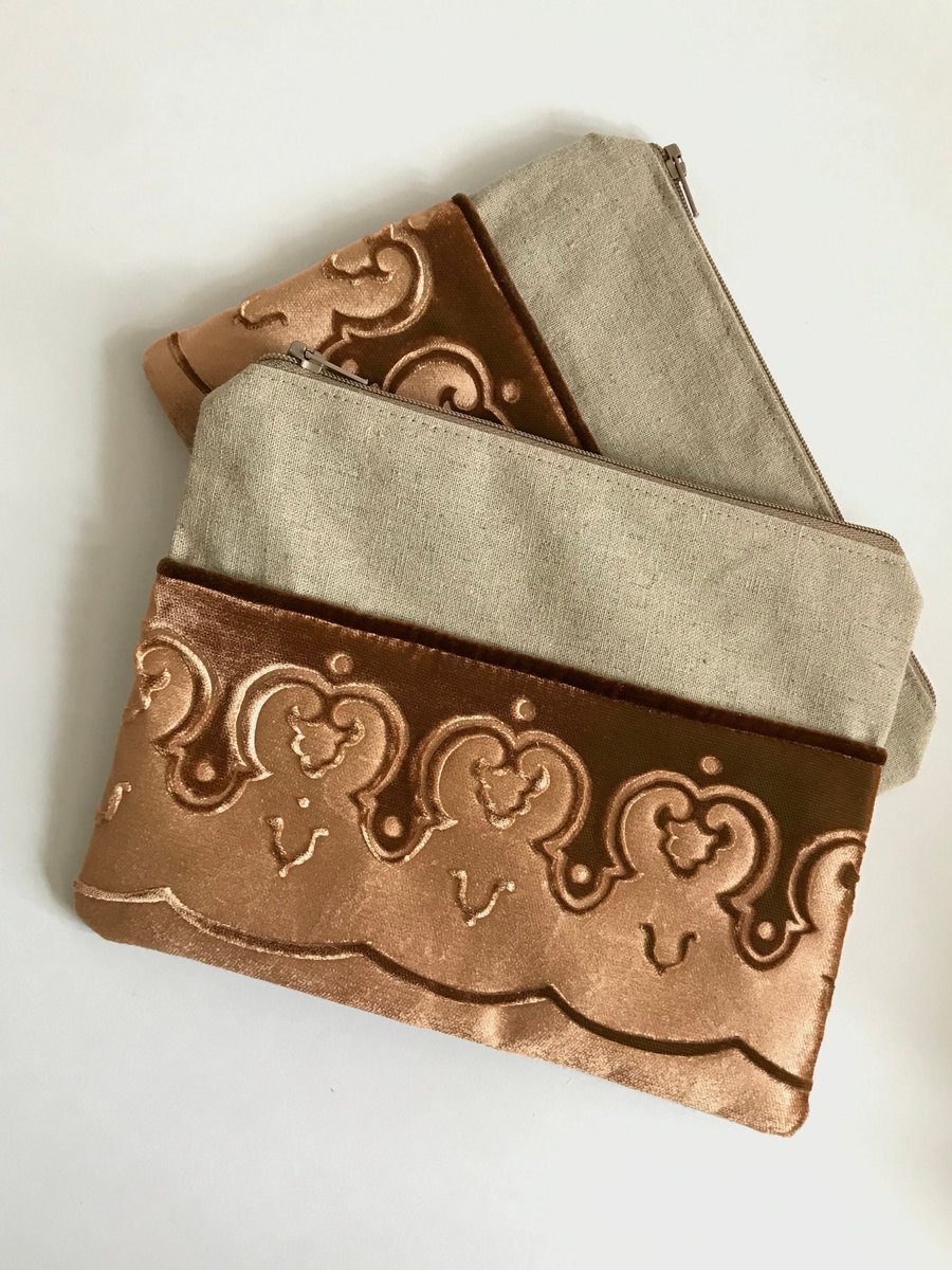Gold zip pouch bag with embossed velvet border and linen design, medium size.