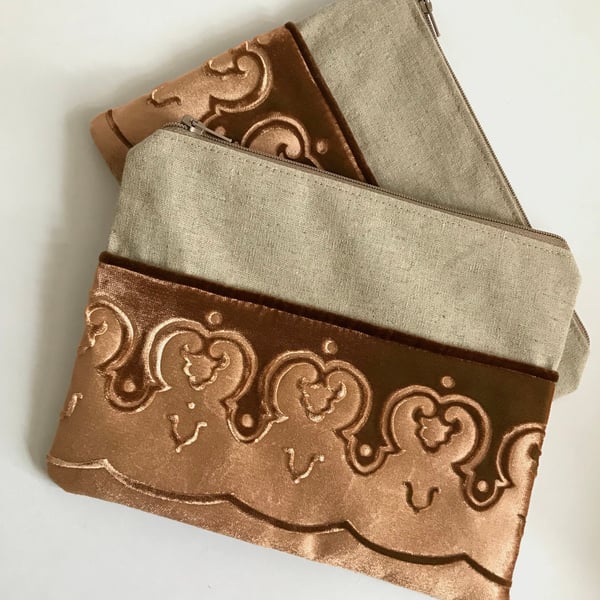 Gold zip pouch bag with embossed velvet border and linen design, medium size.