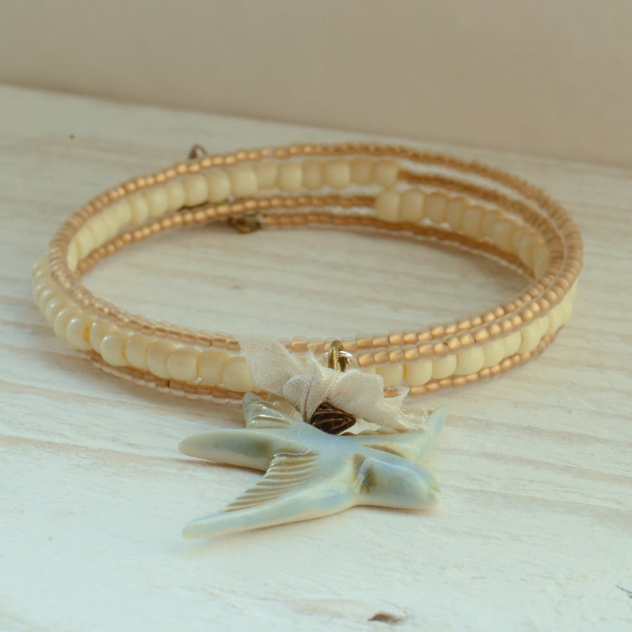 Gold and Cream Memory wire Bracelet with Blue Porcelain Bird