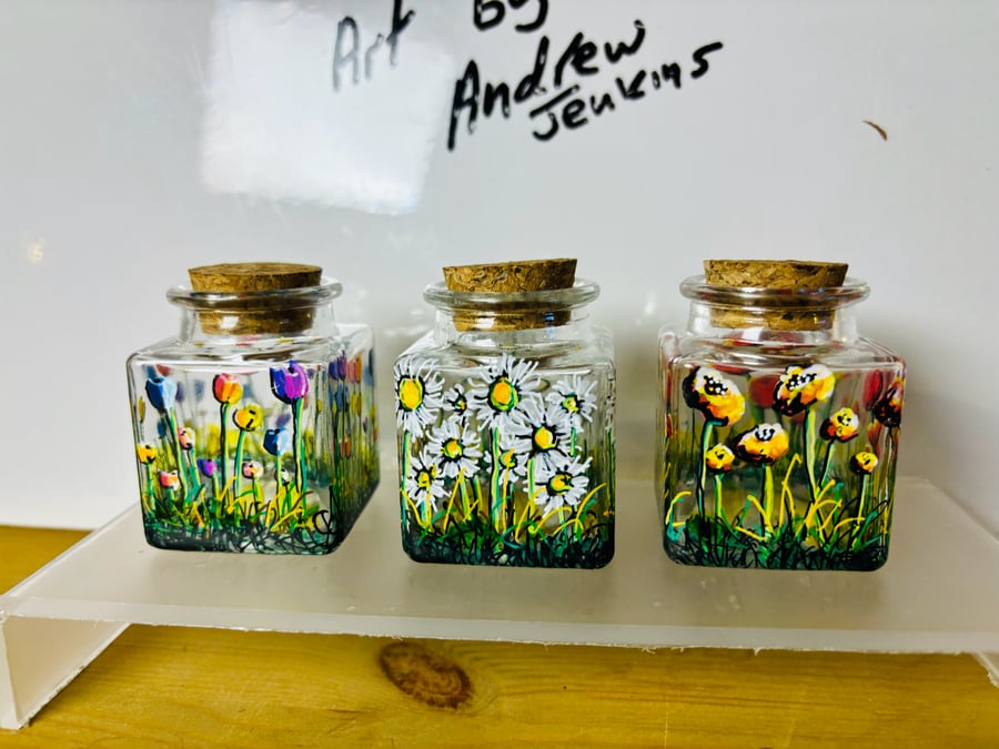A set of three small hand painted and fired glass jars by Andrew Jenkins 