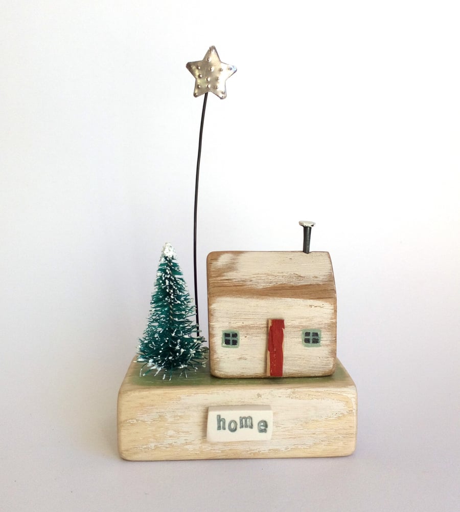 Little wooden house with Christmas tree and star