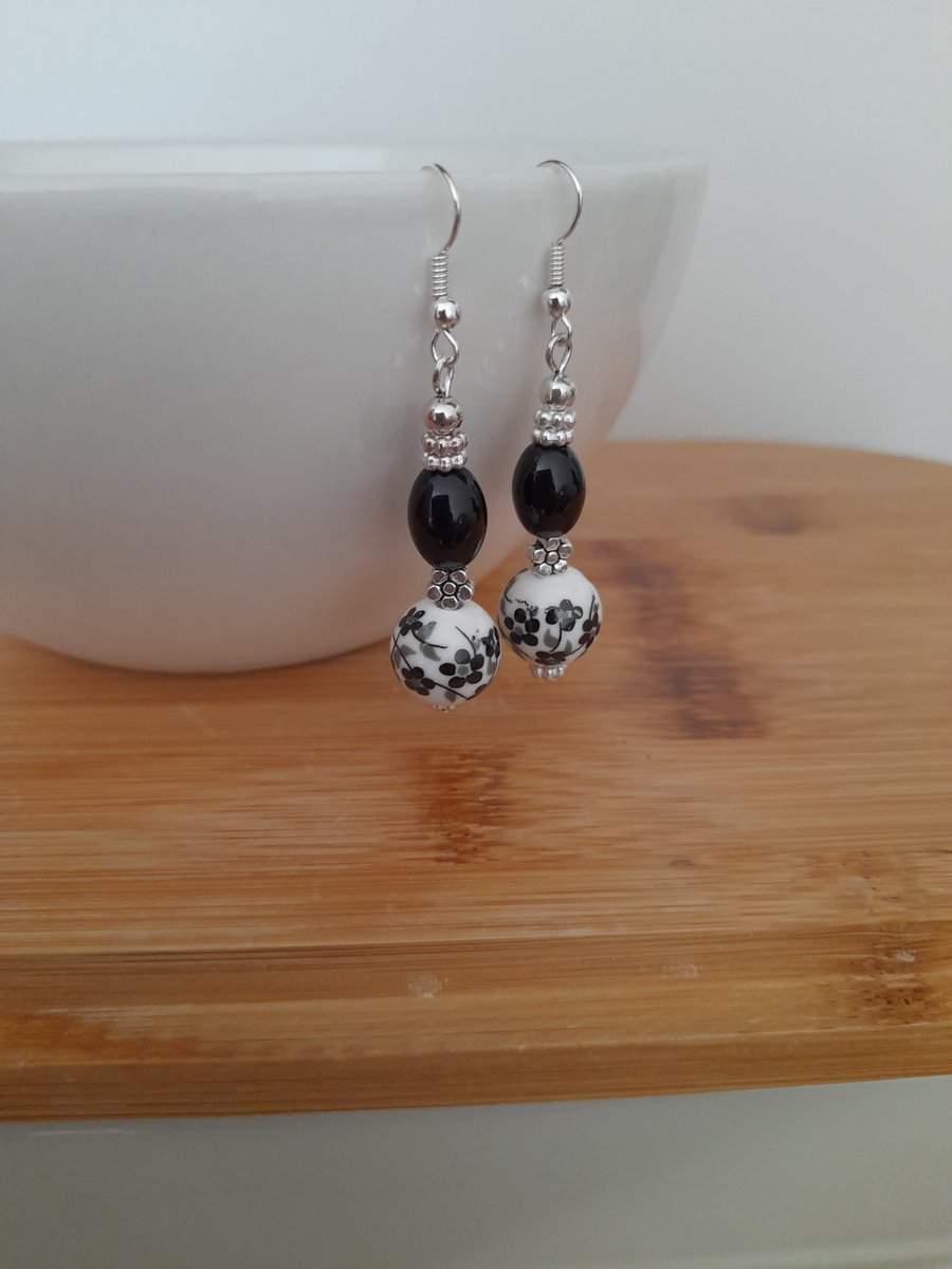 BLACK AND WHITE PORCELAIN FLORAL BEAD EARRINGS. 