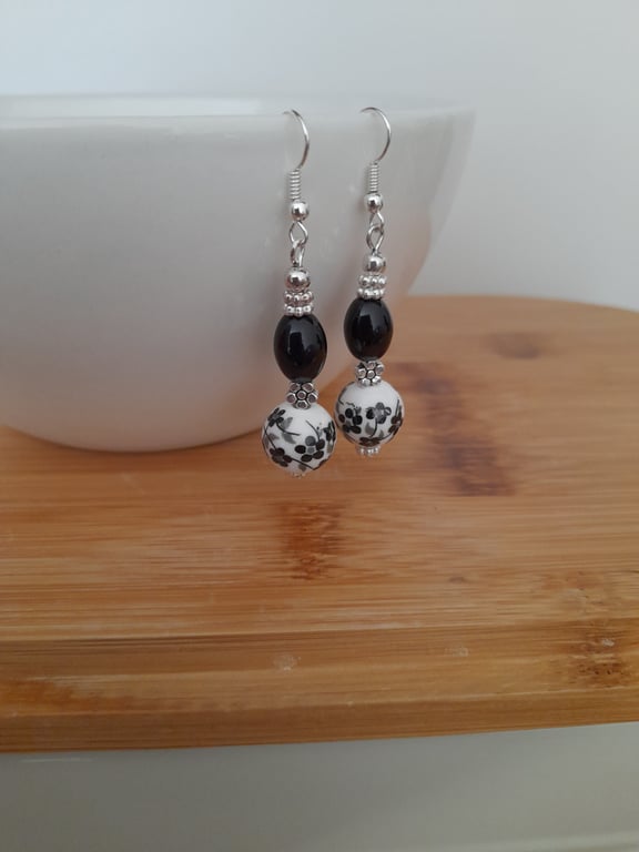 BLACK AND WHITE PORCELAIN FLORAL BEAD EARRINGS. 
