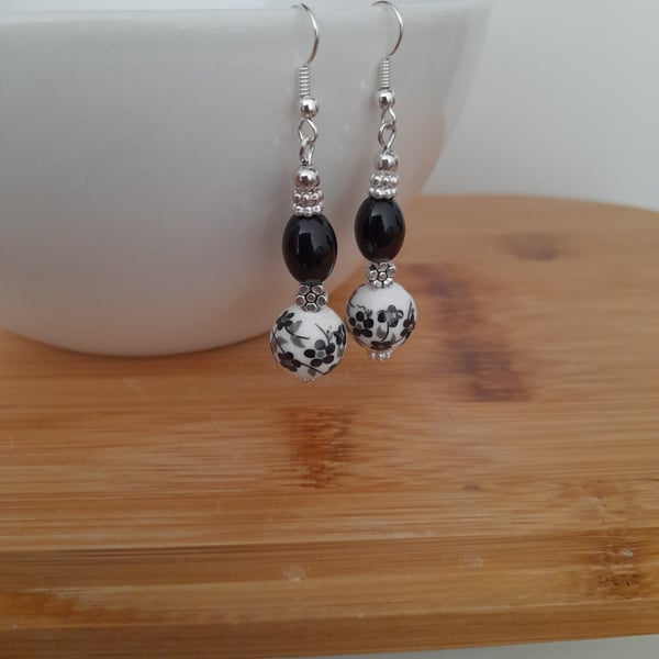 BLACK AND WHITE PORCELAIN FLORAL BEAD EARRINGS. 