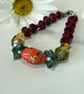 Slender glass bead bracelet in earthy shades of red and orange.  - Image 4