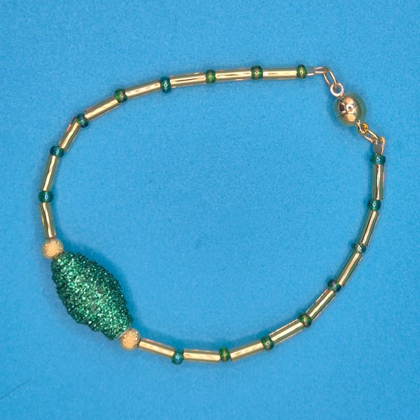 Delicate green and gold bracelet with sparkly paper bead