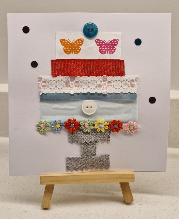 Pretty tiered birthday cake on a stand butterflies-ribbons buttons