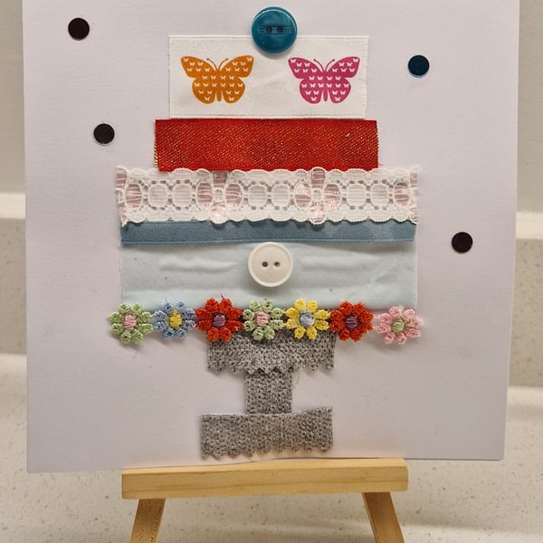 Pretty tiered birthday cake on a stand butterflies-ribbons buttons