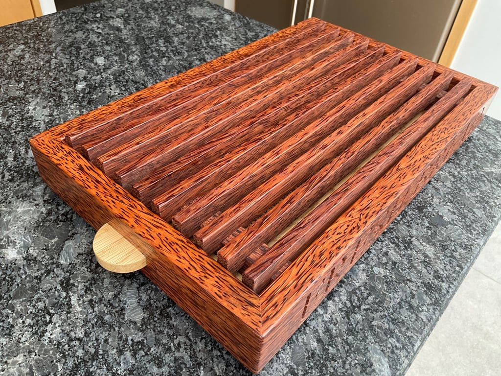 A premier coconut palm and oak crumb catcher bread board