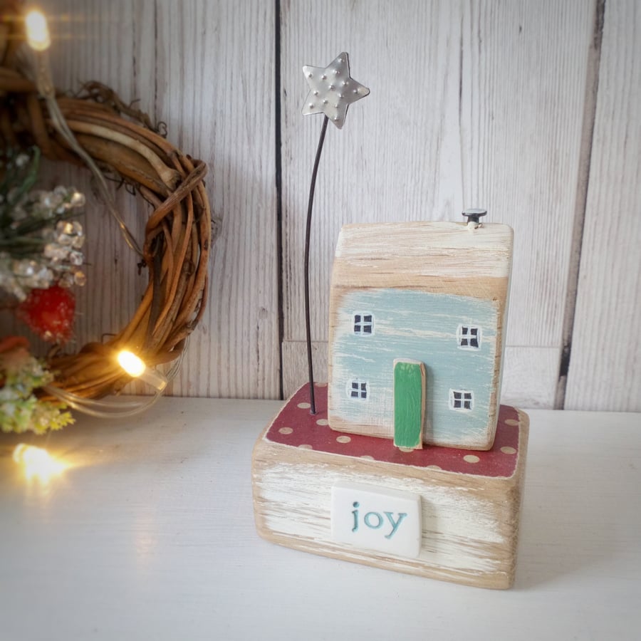 Wooden cottage house with Christmas star 'joy'