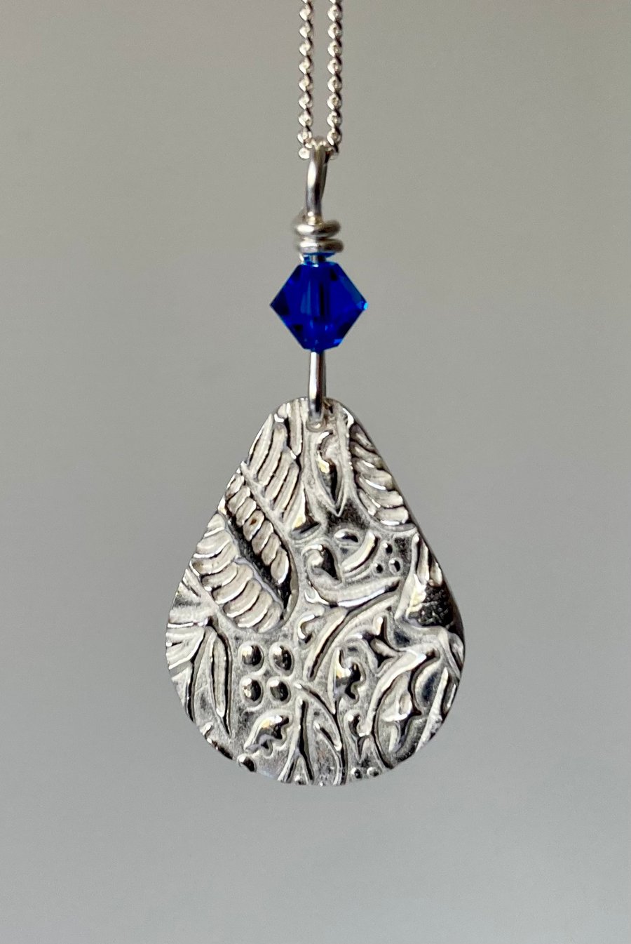 Silver teardrop necklace with blue Swarovski crystal. 