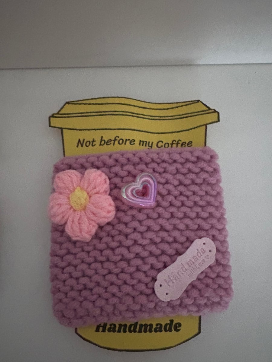Pink heart and flower knitted cup cosy. 