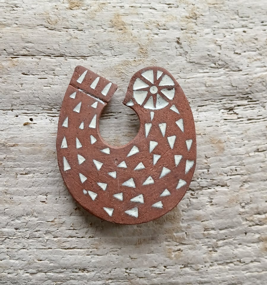 Red clay bird brooch. 