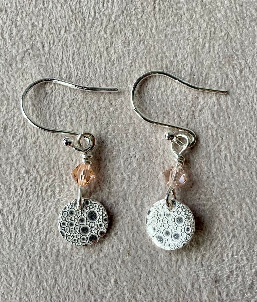 Circular silver earrings with bubble pattern and pale pink Swarovski crystals 