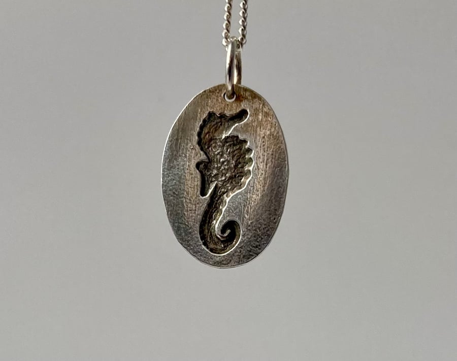 Pure silver necklace with seahorse relief detail. 