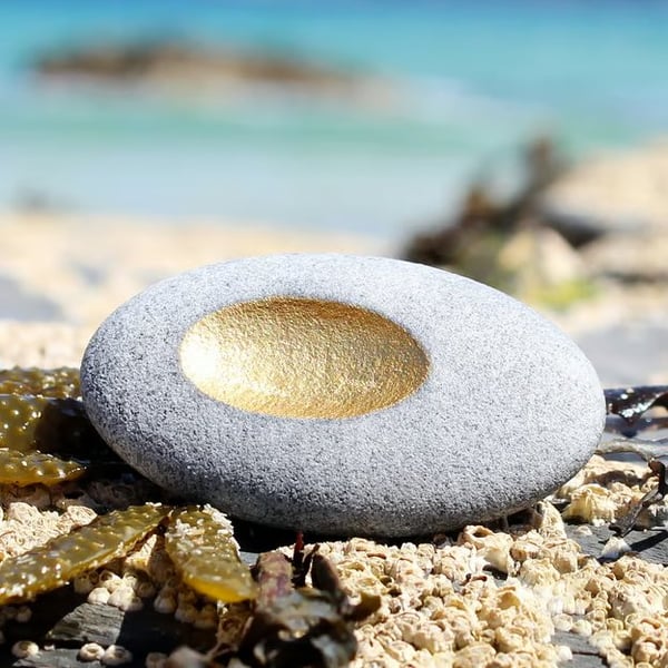 Pebble pendant with golden recess, designed by contemporary jeweller John Field.
