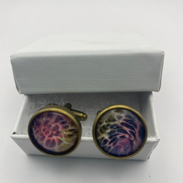 Pair of cuff links with mixed pink, purple, gold and cream pigments 