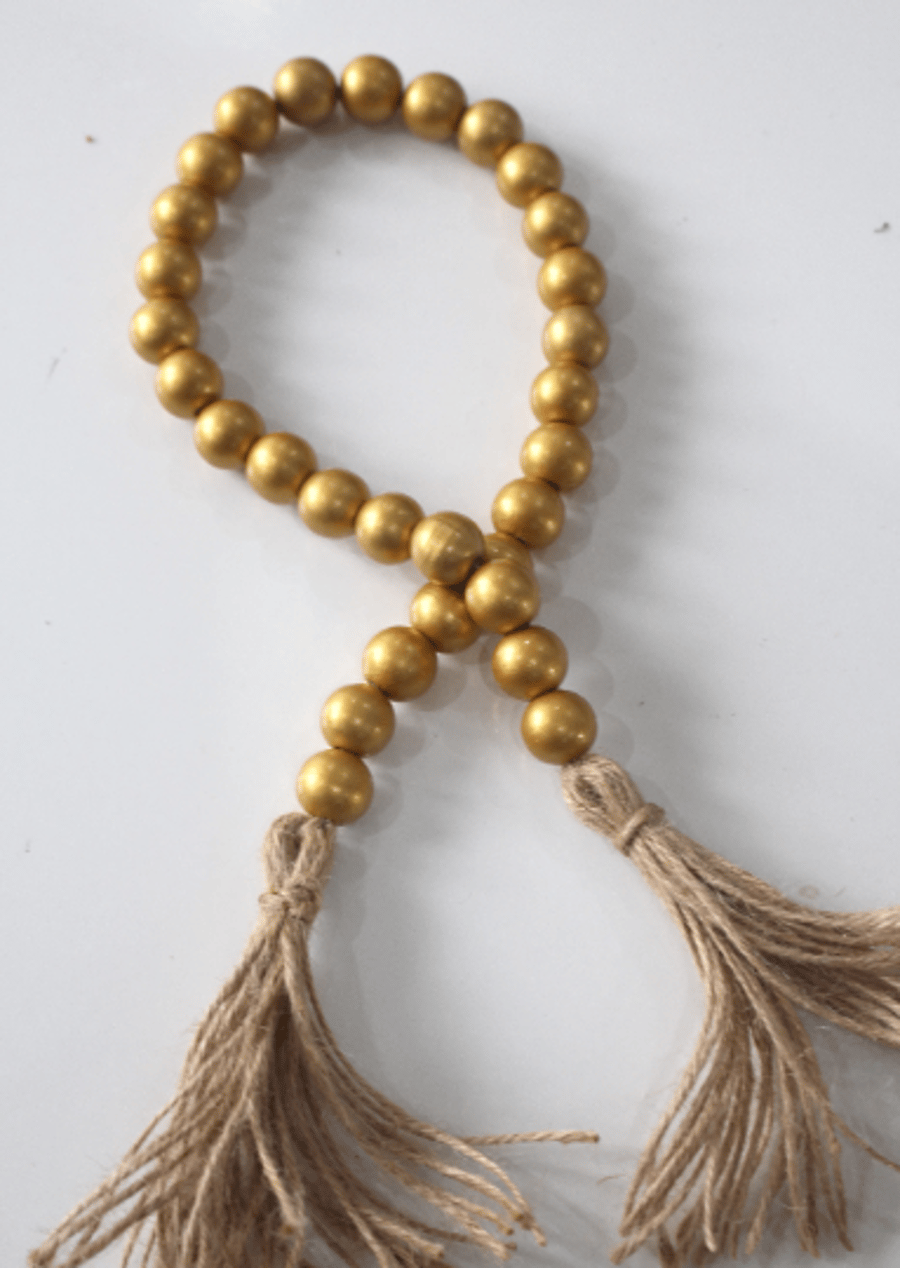 Golden wooden bead garland with jute tassels, boho home decor