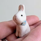 White bunny rabbit with forget me not flower ceramic figurine 