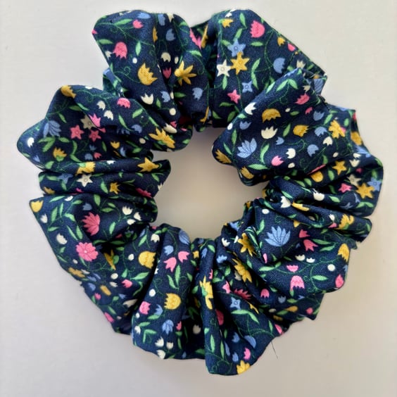 Cotton scrunchie hair accessory in navy with a fun print of bright flowers