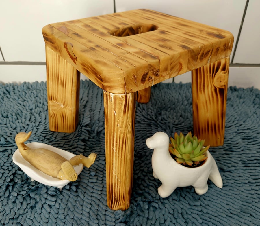 Rustic burnt wooden stool with cutout handle. Farmhouse decor.