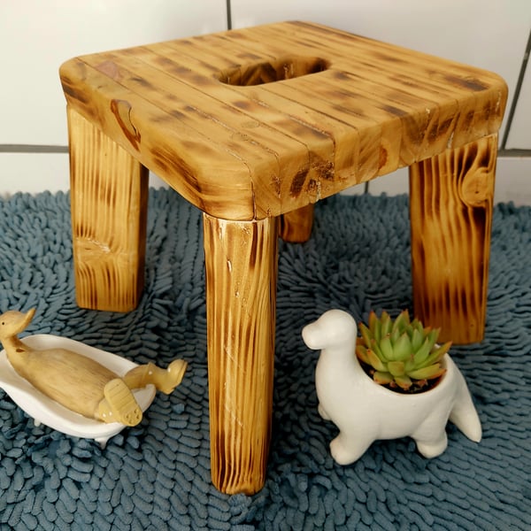 Rustic burnt wooden stool with cutout handle. Farmhouse decor.