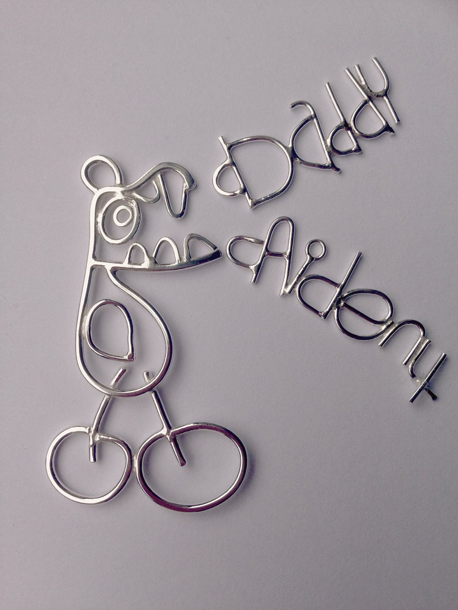 A sterling silver keyring from a childs drawing with 2 childrens writing tags