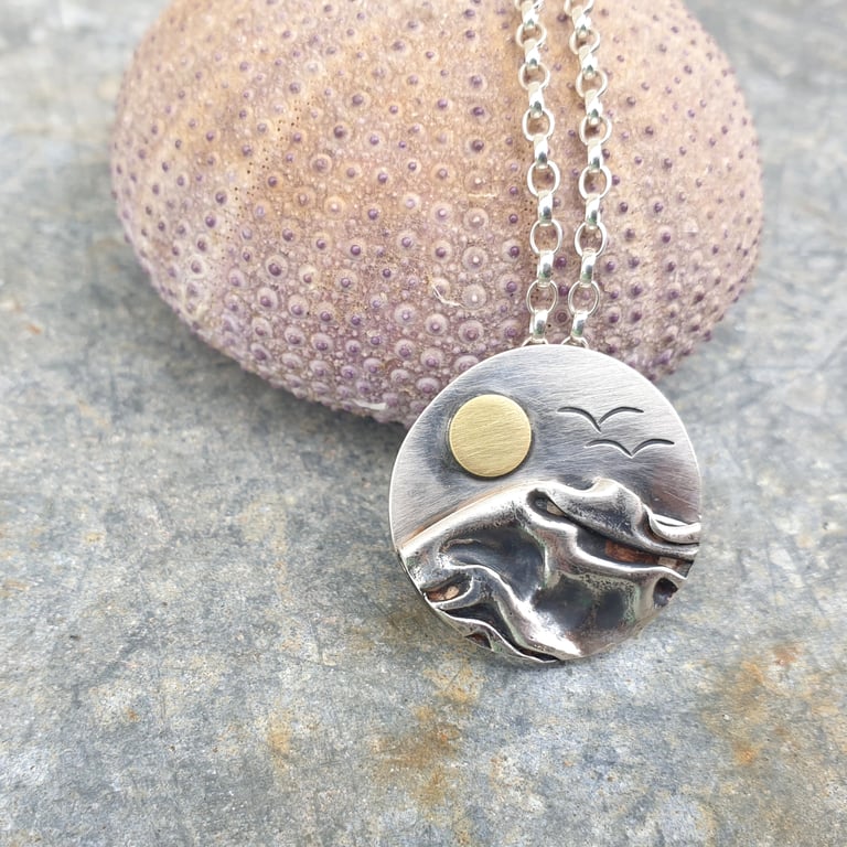 Circular silver, sea coast sunrise pendant, with brass sun and seagulls