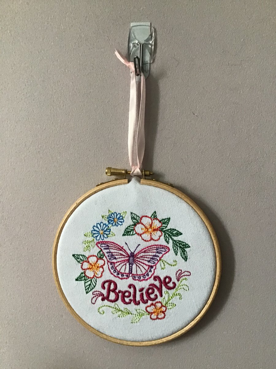 Believe and butterfly embroidered wall decoration.