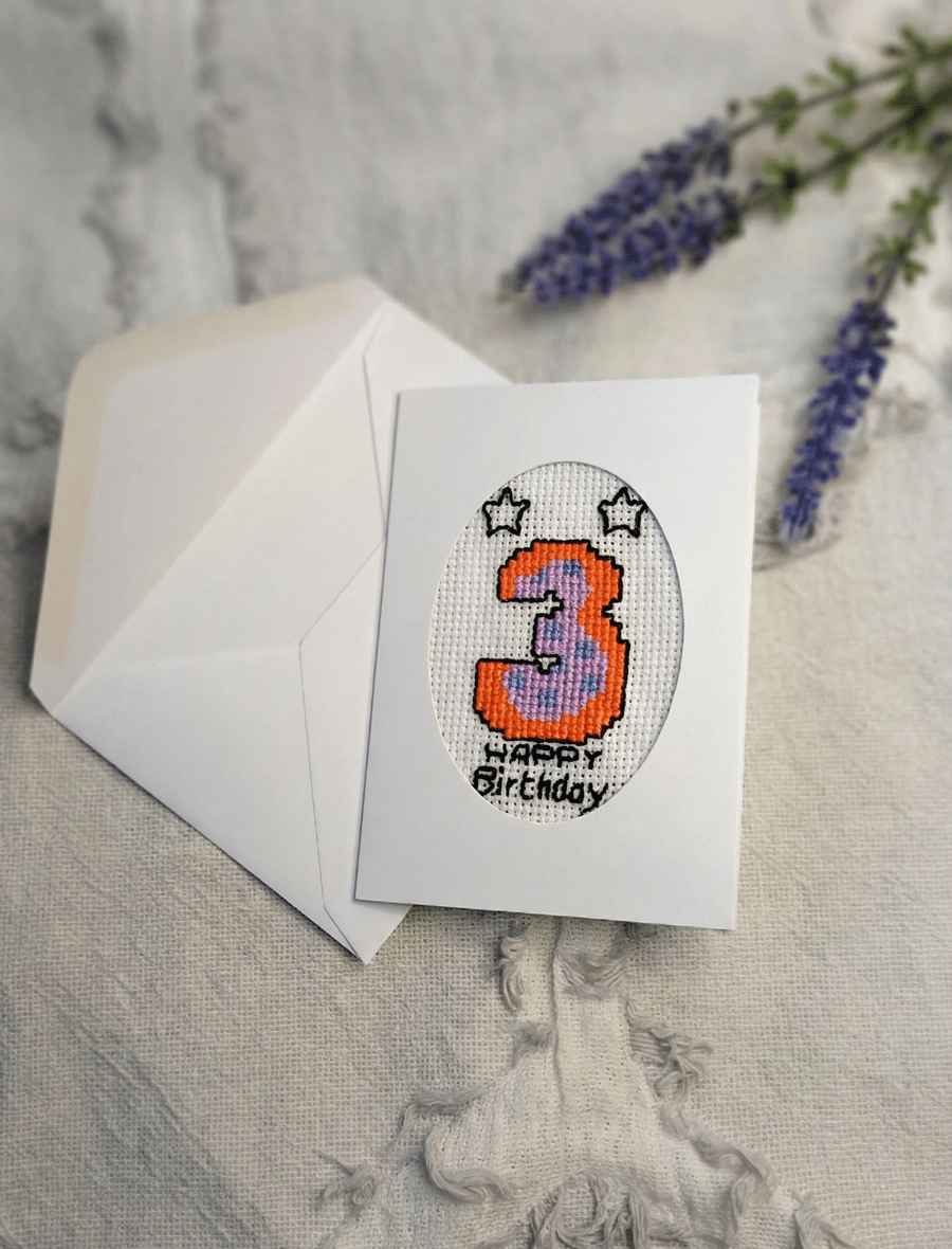 Hand stitched age three birthday card featuring a colourful cross stitch