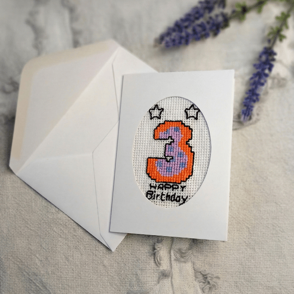 Hand stitched age three birthday card featuring a colourful cross stitch